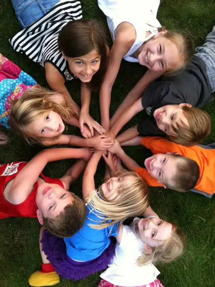 Young children putting their hands together to showcase togetherness