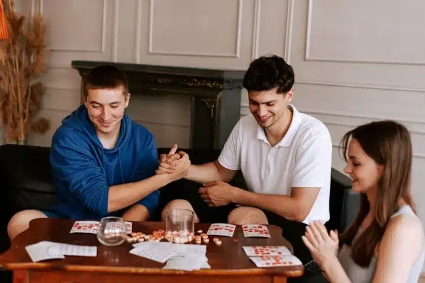 a group of people sitting around a table playing cards