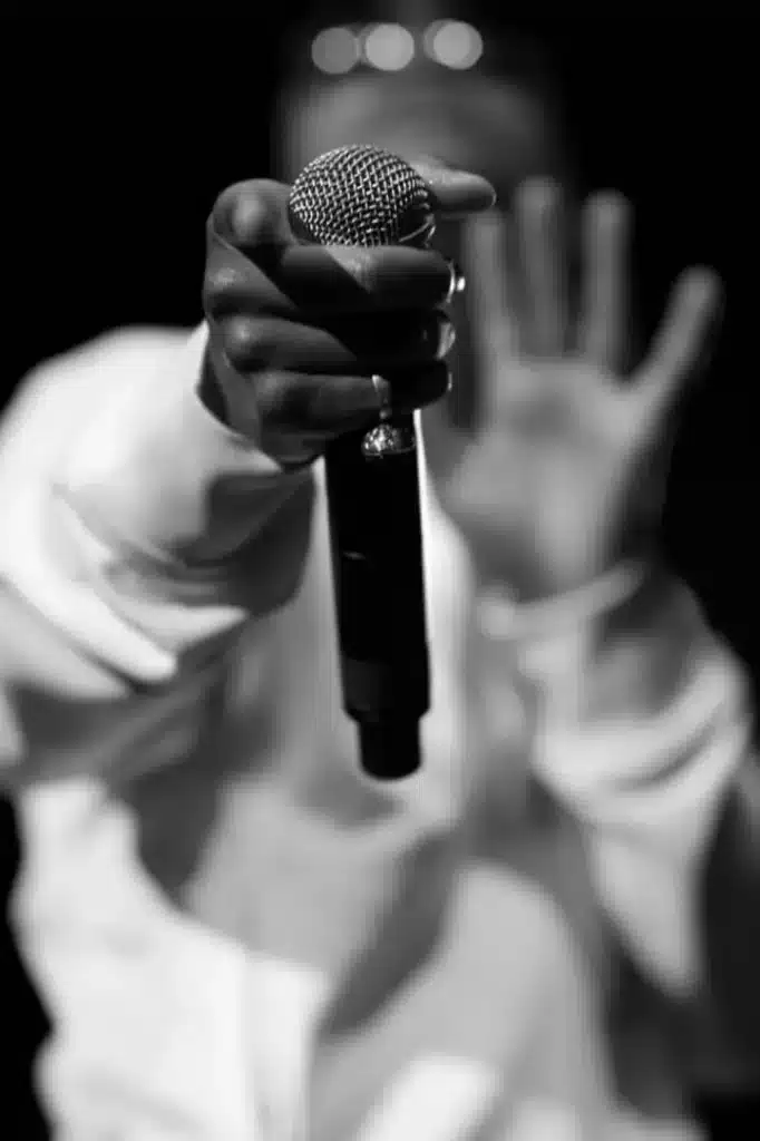 A hand with a ring holding onto a microphone